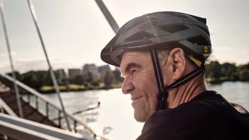 JobRadler auf Fahrradbrücke fährt grinsend in den Feierabend JobRadler auf Fahrradbrücke fährt grinsend in den Feierabend
