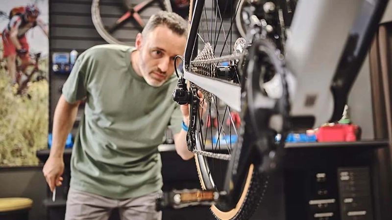 Ein Fachhändler blickt auf ein Hinterrad Ein Fachhändler blickt auf ein Hinterrad