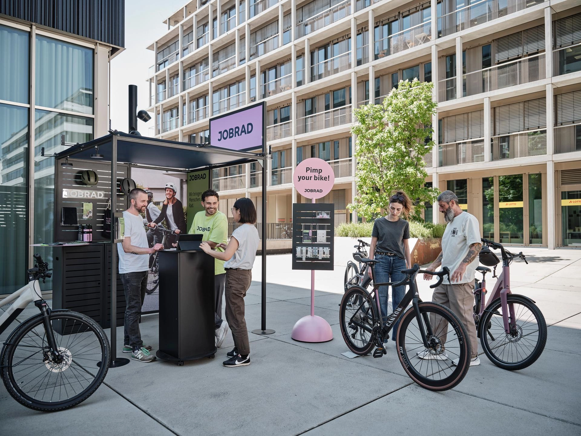 Beratungssituation am JobRad-Stand. Zentral ein Sticker-Aufsteller mit Schild "Pimp your Bike" Beratungssituation am JobRad-Stand. Zentral ein Sticker-Aufsteller mit Schild "Pimp your Bike"